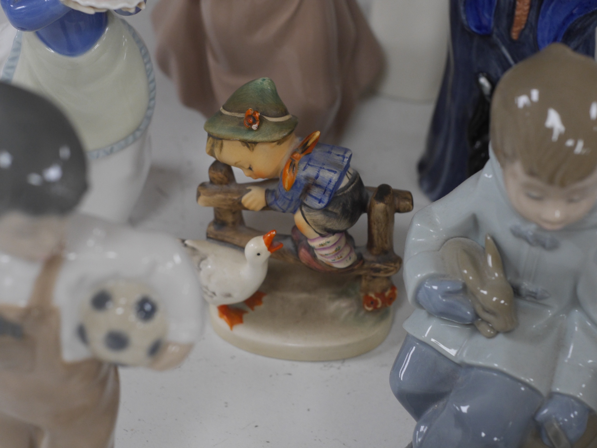 A Royal Doulton figure ‘The Wizard’ HN 2877, together with a quantity of Nao figures, Royal Worcester and Hummel figures, The Wizard 25cm high. Condition - Hummel figure chip to hat, NAO figure with candle holder, opposi